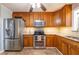 Charming kitchen with stainless steel appliances, tiled backsplash, oak cabinets, and tiled floors at 2421 Pittman Cir, Cumming, GA 30040