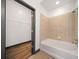 Bathroom featuring tiled walls, tub, and a view into an organized closet space at 5300 Peachtree Rd # 3507, Chamblee, GA 30341