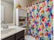This bathroom features a pedestal sink with a bright and colorful shower curtain and a cabinet for storage at 7420 Glisten Ave, Sandy Springs, GA 30328