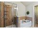 Relax in this updated bathroom, featuring a tiled shower, soaking tub, and chrome hardware and fixtures at 7420 Glisten Ave, Sandy Springs, GA 30328