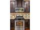Kitchen features stainless steel appliances, dark wood cabinets, granite countertops, and tile backsplash at 7420 Glisten Ave, Sandy Springs, GA 30328