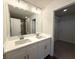 Bright bathroom with double sinks, white countertop and a large mirror with modern lighting at 5455 Blossomwood Sw Trl, Mableton, GA 30126