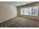 Comfortable bedroom with plush carpeting and a large window providing natural light at 5455 Blossomwood Sw Trl, Mableton, GA 30126