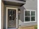 Home exterior featuring a dark front door, modern light fixture, and the house number at 5455 Blossomwood Sw Trl, Mableton, GA 30126