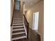 Interior shot of a staircase with modern railings and hardwood floors leading to the upper level at 5455 Blossomwood Sw Trl, Mableton, GA 30126