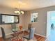 Dining room featuring a glass table, chandelier, and a window into the kitchen at 3011 Waldrop Cir, Decatur, GA 30034