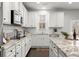 Bright kitchen with white cabinets, granite countertops, subway tile backsplash, and stainless steel appliances at 485 St Annes Pl, Covington, GA 30016