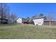 Expansive backyard showcasing a wooden deck, carport, storage building and large grassy area at 8321 Banks Mill Rd, Douglasville, GA 30135