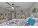 Bedroom with floral bedding, modern fan, and built-in shelving at 8321 Banks Mill Rd, Douglasville, GA 30135