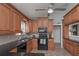 Bright eat-in kitchen featuring tile floors, wood cabinets, and black appliances at 8321 Banks Mill Rd, Douglasville, GA 30135