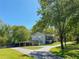 Exterior view of a light gray home with a large driveway, carport, and lawn at 8321 Banks Mill Road Rd, Douglasville, GA 30135