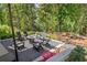 Inviting backyard with gravel patio, cozy fire pit, and comfortable seating surrounded by lush greenery at 1290 Lupo Loop, Chattahoochee Hills, GA 30268