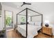 Bedroom featuring a four-poster bed, hardwood floors, and natural light from the back door at 1290 Lupo Loop, Chattahoochee Hills, GA 30268