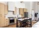 Modern kitchen with stainless steel appliances, light wood cabinetry, and eat-in island at 1290 Lupo Loop, Chattahoochee Hills, GA 30268