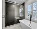 Bathroom featuring a walk-in shower with black tile and a freestanding soaking tub at 474 Maxwell Rd, Roswell, GA 30075