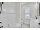 Modern bathroom featuring white tile, a bathtub, a window, and a vanity sink at 474 Maxwell Rd, Roswell, GA 30075