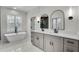 Bathroom featuring double sinks, modern fixtures, tub and vanity at 474 Maxwell Rd, Roswell, GA 30075