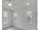 Bright bedroom featuring gray carpet, ceiling fan, and three sunny windows at 474 Maxwell Rd, Roswell, GA 30075