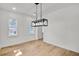 Dining room with modern light fixture, neutral paint, and views from two windows at 474 Maxwell Rd, Roswell, GA 30075
