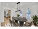 Dining room with modern light fixture, neutral paint, and views from two windows at 474 Maxwell Rd, Roswell, GA 30075