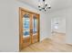 Bright entryway featuring hardwood floors, white walls, double wood doors, and modern lighting at 474 Maxwell Rd, Roswell, GA 30075