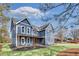 A blue two-story home featuring a welcoming front porch, well-manicured lawn, and driveway at 474 Maxwell Rd, Roswell, GA 30075