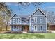 A charming two-story blue home featuring a welcoming front porch and professionally landscaped front yard at 474 Maxwell Rd, Roswell, GA 30075