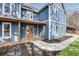 Inviting blue two-story home boasts a charming front porch and manicured landscaping at 474 Maxwell Rd, Roswell, GA 30075