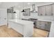 Modern kitchen with a white island, gray cabinets, stainless steel appliances, and bright white tile backsplash at 474 Maxwell Rd, Roswell, GA 30075