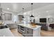 A kitchen open to the living room featuring gray cabinets, modern lighting and stainless steel appliances at 474 Maxwell Rd, Roswell, GA 30075