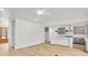 Bright, open-concept living space with hardwood floors and view of the adjacent kitchen featuring stainless steel appliances at 474 Maxwell Rd, Roswell, GA 30075