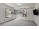 A carpeted basement space with two windows, an accent wall, and a wall-mounted TV at 1290 Regency Center Sw Dr, Atlanta, GA 30331