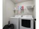 Laundry room featuring modern washer and dryer units with wire shelving above at 1290 Regency Center Sw Dr, Atlanta, GA 30331
