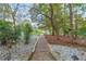 Stone path with landscape lighting leading to the home with beautiful wooded scenery and a white stone border at 1806 Wynthrop Manor Sw Dr, Marietta, GA 30064