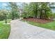 Long concrete driveway with green grass and trees lining the sides leading up to the property at 1806 Wynthrop Manor Sw Dr, Marietta, GA 30064