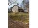 A spacious backyard featuring a deck, mature trees, a partial fence line and a large grassy area at 4155 Gables Pl, Buford, GA 30519