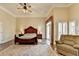 Large main bedroom with hardwood floors, a ceiling fan, a seating area, and a decorative wooden bed frame at 5180 Cameron Forest Pkwy, Johns Creek, GA 30022