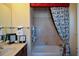 Charming bathroom featuring a tub with a decorative curtain and patterned towels, a vanity with framed pictures at 6026 Southland Dr, Stone Mountain, GA 30087