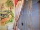 Quaint bathroom with decorative mural, shower with floral shower curtain, and ornate design at 6026 Southland Dr, Stone Mountain, GA 30087