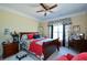 An elegant bedroom with wood furniture, a ceiling fan, red accents, and classic decor at 6026 Southland Dr, Stone Mountain, GA 30087