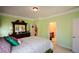 Bedroom featuring light green walls, traditional-style furniture, and doorway to an en-suite bathroom at 6026 Southland Dr, Stone Mountain, GA 30087