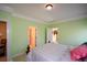 A stylish bedroom with light-green walls, white trim and doors, and a view into the walk-in closet at 6026 Southland Dr, Stone Mountain, GA 30087