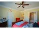Bedroom featuring wood furniture, ceiling fan, a doorway to an en-suite bathroom, and classic decor at 6026 Southland Dr, Stone Mountain, GA 30087