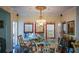 Dining room features a glass table, chandelier, large windows with custom drapes, and decorative accents at 6026 Southland Dr, Stone Mountain, GA 30087
