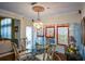 Dining room features a glass table, ornate chandelier, and large windows with custom drapes at 6026 Southland Dr, Stone Mountain, GA 30087