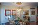 Dining room features a glass table, chandelier, large windows with custom drapes, and decorative accents at 6026 Southland Dr, Stone Mountain, GA 30087