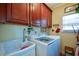 A functional laundry room with modern washer and dryer, ample cabinet space, and a convenient utility sink at 6026 Southland Dr, Stone Mountain, GA 30087