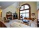Spacious living room with tall ceilings features stone fireplace, arched window, white sectional sofa, and chandelier at 6026 Southland Dr, Stone Mountain, GA 30087