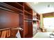 Large walk-in closet boasts custom dark-wood shelving and storage, providing ample space at 6026 Southland Dr, Stone Mountain, GA 30087