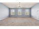 Spacious bonus room with neutral carpet, three windows and a modern light fixture at 5170 Black Bear Trl, Douglasville, GA 30135